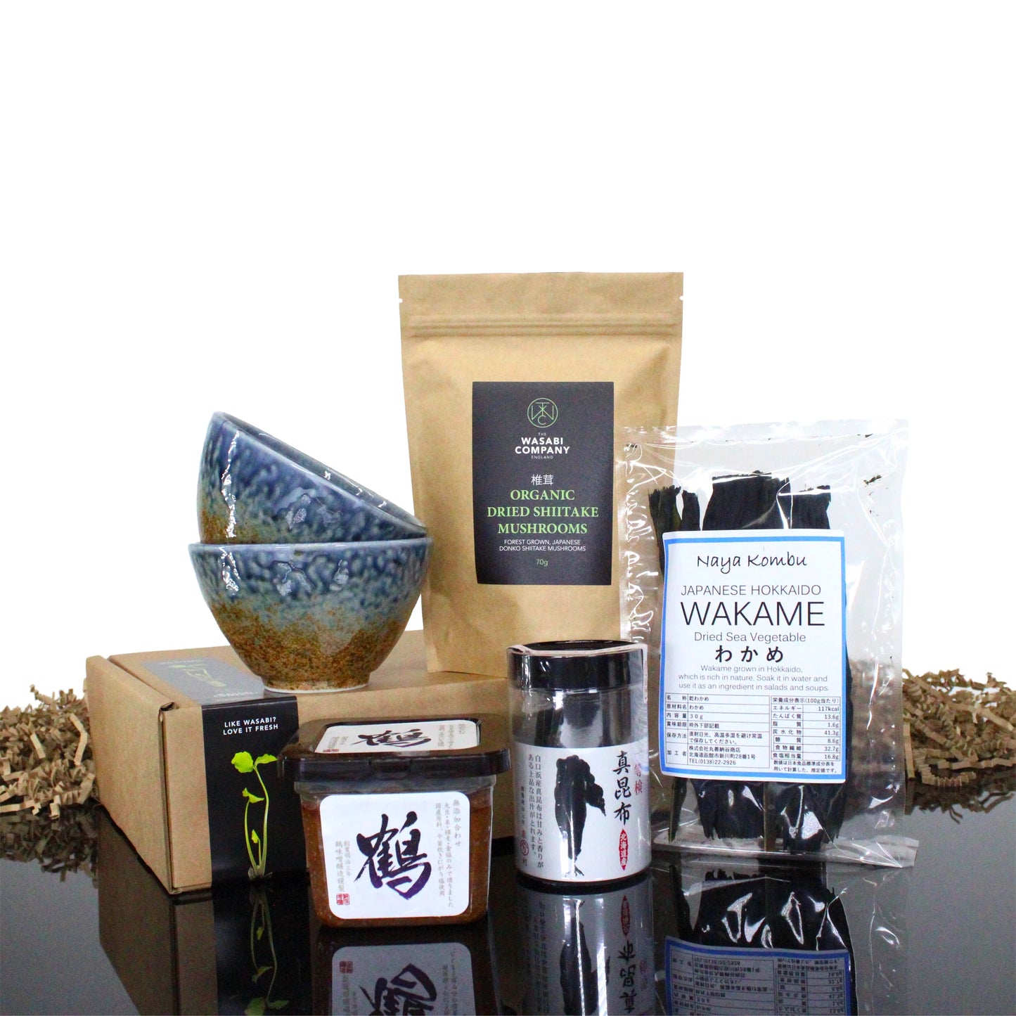 The Miso Soup Kit with Miso Bowls includes kombu seaweed, dried shiitake mushrooms, two miso bowls, and two condiment containers, all neatly arranged together.