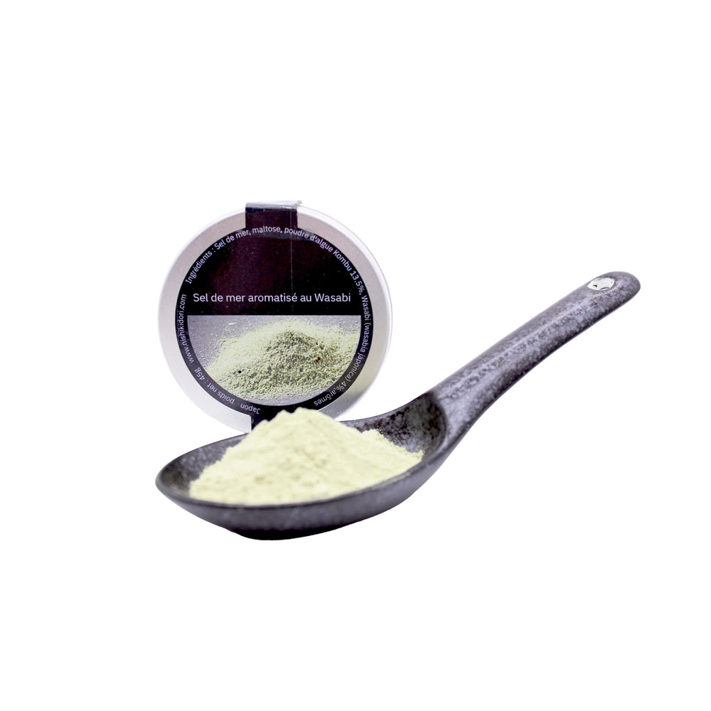 
                  
                    A black spoon filled with Wasabi Sea Salt - 45g powder is placed in front of a round container labeled Sel de mer aromatisé au Wasabi.
                  
                