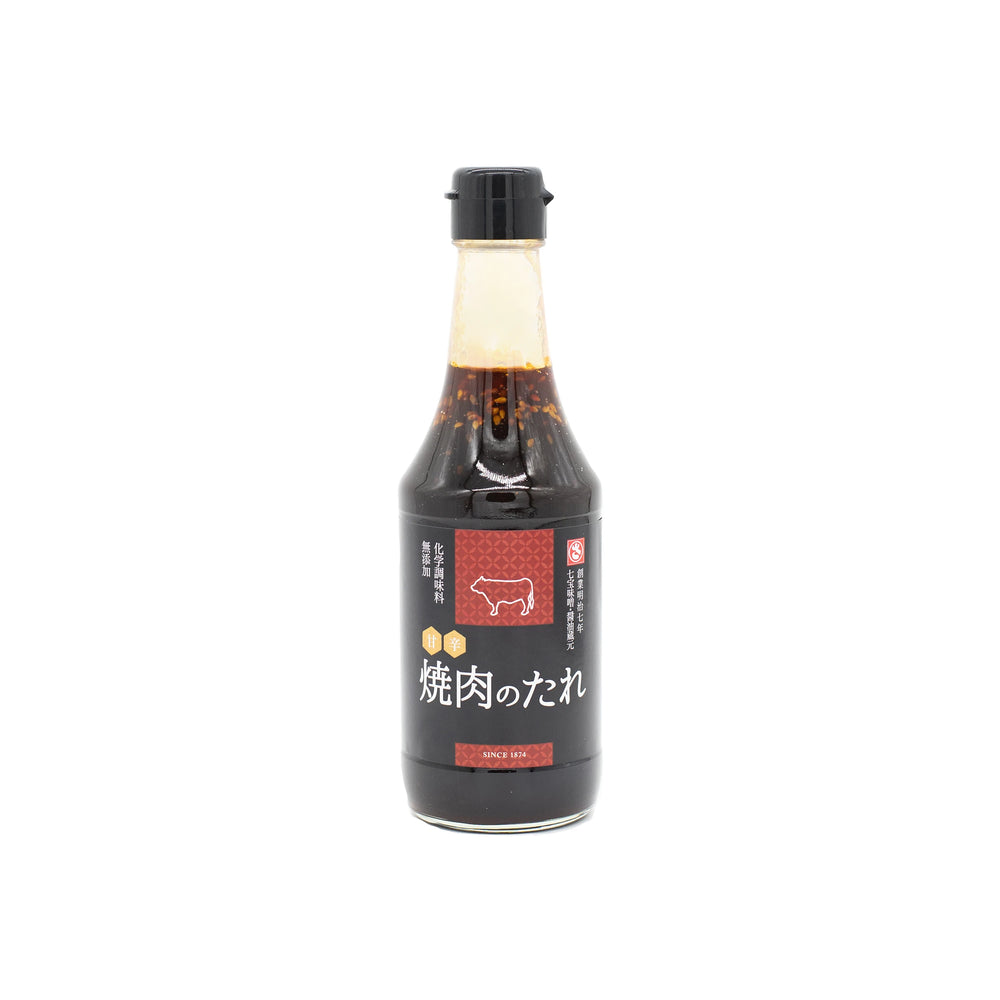 Yakiniku Barbecue Sauce - 300ml comes in a bottle with a black cap, featuring Japanese text, a cow illustration, and visible sesame-flavored sauce—ideal for elevating your Japanese cuisine experience.