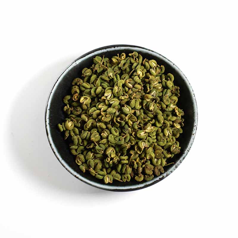 A black bowl of Green Budo Sansho Berries - 25g, dried and aromatic with a citrus scent, viewed from above on a white background.