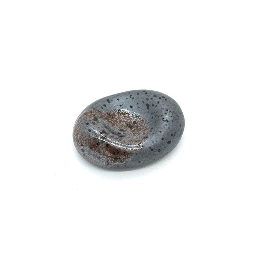 A smooth, pebble-shaped chopstick rest in matte black with a splash design, inspired by Japanese river stones, makes an elegant table accessory—Chopstick Rest – Pebble Shape Matt Black with Splash.