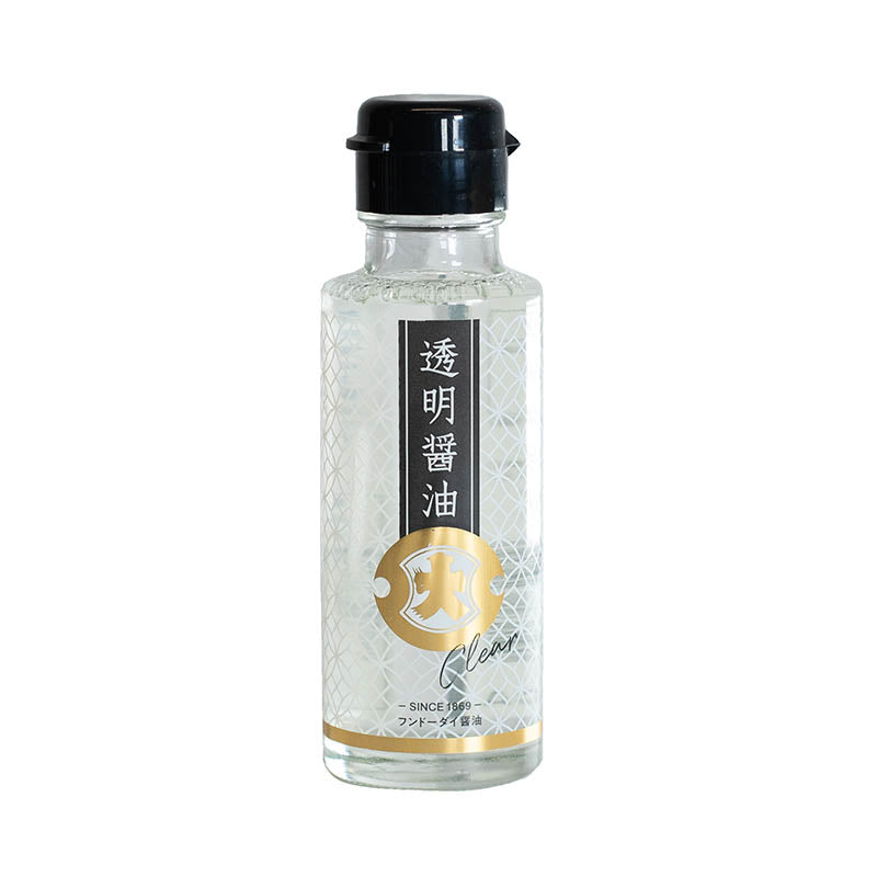 The Crystal Clear Soy Sauce - 100ml comes in a clear glass bottle with a black cap, featuring Japanese text and gold accents on the label, and offers a unique, transparent soy sauce from Japan.