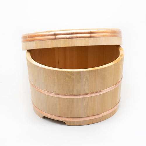 
                  
                    The Ohitsu, Cypress Wood Rice Bowl with Lid, features two copper bands and a slightly open lid, displayed against a plain white background.
                  
                