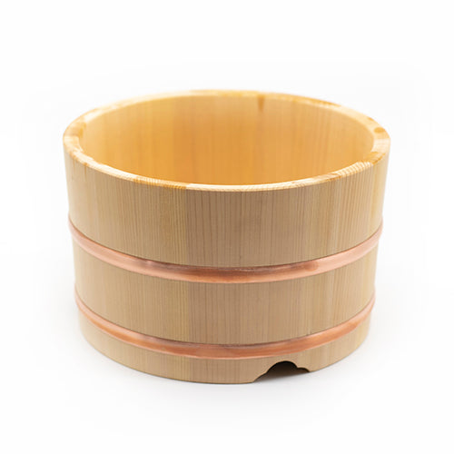 
                  
                    The Ohitsu, Cypress Wood Rice Bowl with Lid features a round shape, two copper bands at the middle, and a small notch at the base—ideal for serving sushi rice. Photographed on a white background.
                  
                