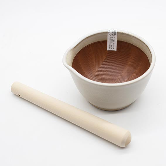 The Suribachi Motoshige Pestle & Mortar - White features a ridged ceramic interior and wooden pestle, ideal for grinding sesame seeds in Japanese cuisine, shown here against a white background.