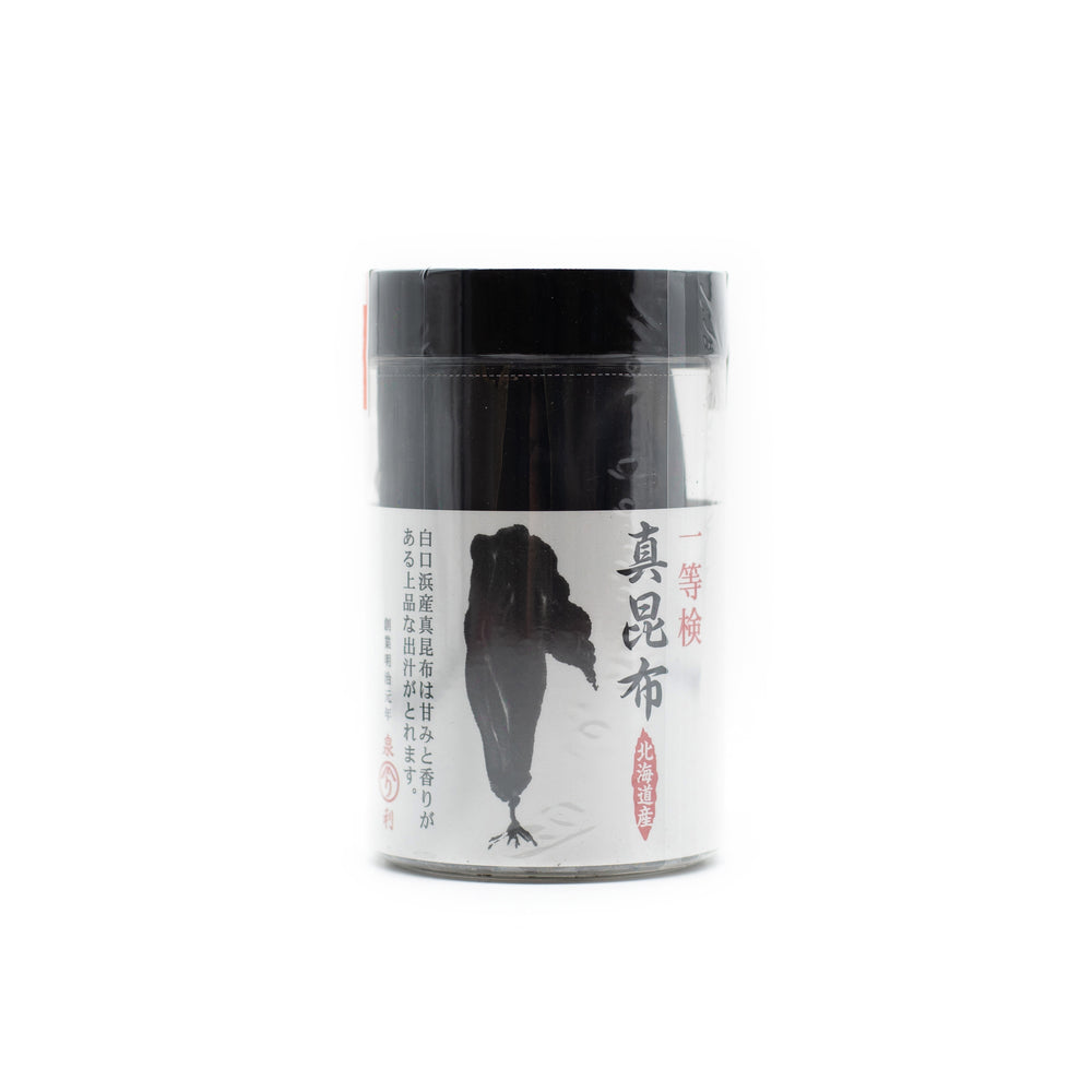 Ma Kombu 25g comes in a cylindrical container with Japanese text and an illustration of dark seaweed on a white label; it contains dried Hokkaido kombu, perfect for making dashi stock.
