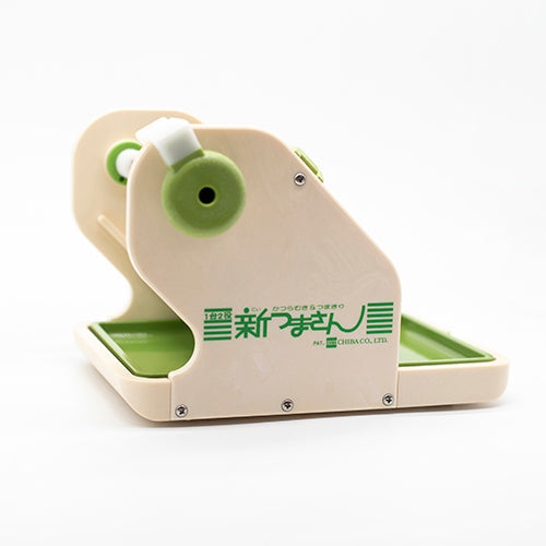 
                  
                    The Vegetable & Fruit Cutter, a beige and green plastic slicer with Japanese text, features a handle and tray and is shown against a plain white background.
                  
                