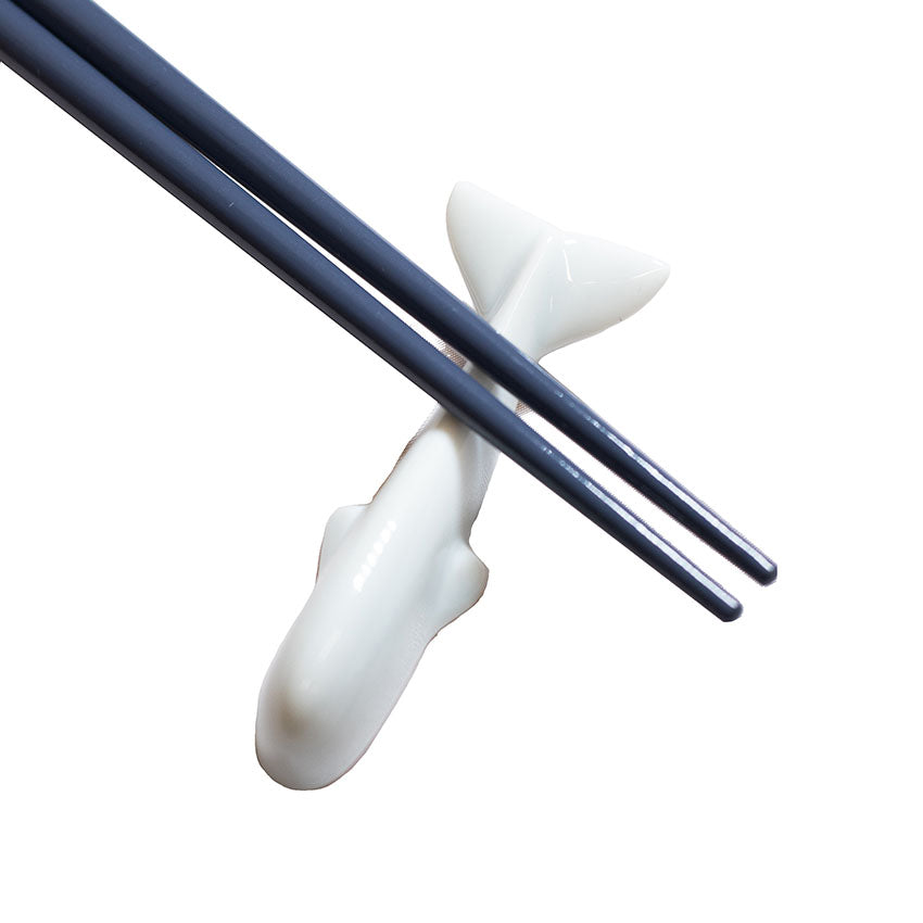 
                  
                    A pair of dark chopsticks rests on the Whale Chopstick Rest - White, a charming piece crafted from Minoyaki porcelain.
                  
                