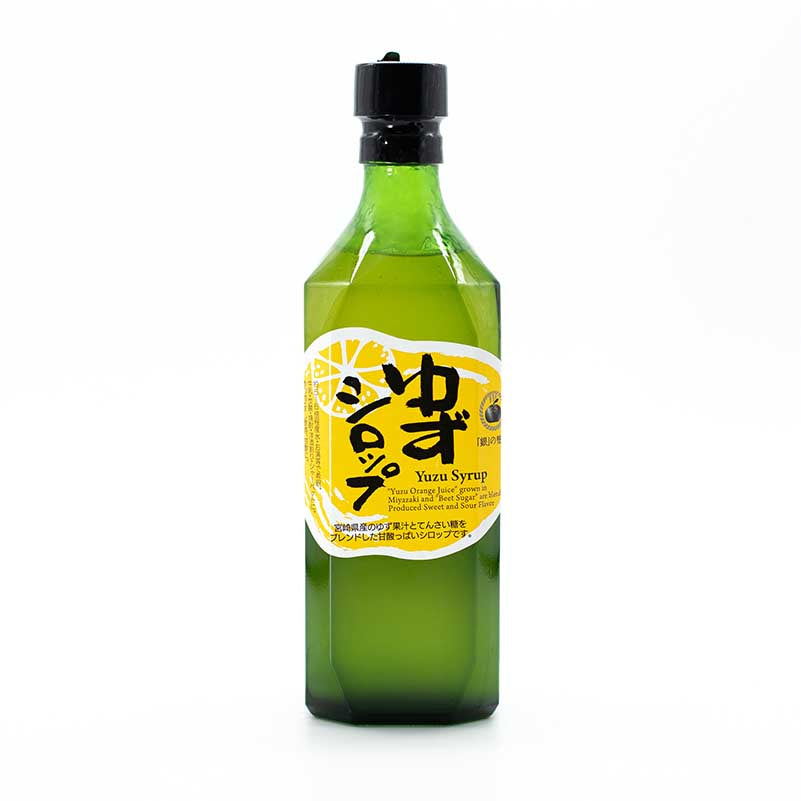 A green bottle labeled in Japanese and English as Yuzu Syrup from Miyazaki - 500ml, featuring a yellow label with a yuzu fruit slice illustration, highlights its citrus flavor from Miyazaki, Japan.
